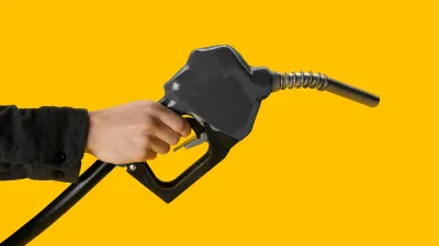 A hand holding a gas pomp infront of a yellow background A hand holding a gas pomp infront of a yellow background