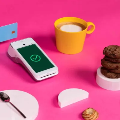 Android payment terminal next to coffee, cookies, and white shapes Android payment terminal next to coffee, cookies, and white shapes