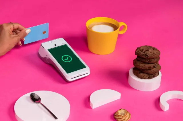 Android payment terminal next to coffee, cookies, and white shapes